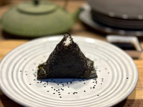 Onigiri z tuńczykiem podane z sosem sojowym, posypane czarnym sezamem