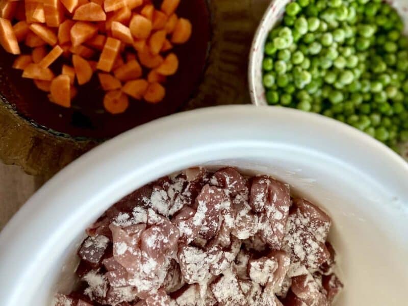 Składniki na gulasz wieprzowy w sosie własnym: zielony groszek, wieprzowina, i marchewka