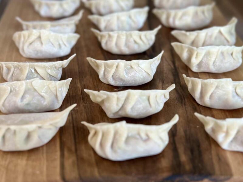 Sklejone pierożki gyoza na desce przed gotowaniem