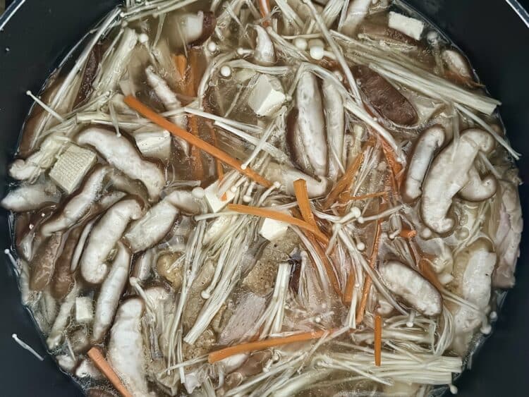 Zupa z kurczakiem, tofu, marchewką i grzybami w garnku